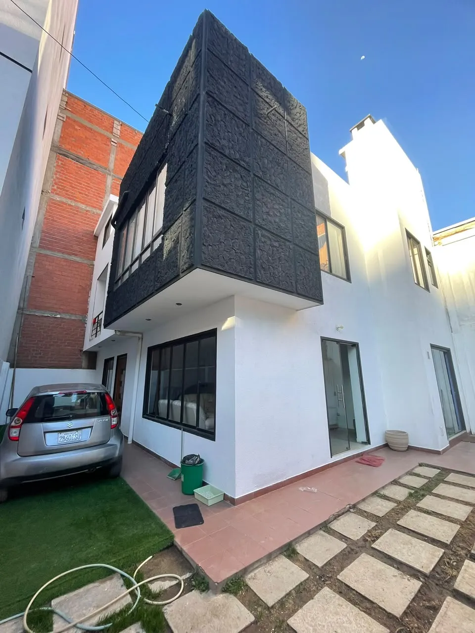 Fachada de la casa en Zona Quirpinchaca con ingreso vehicular y jardín